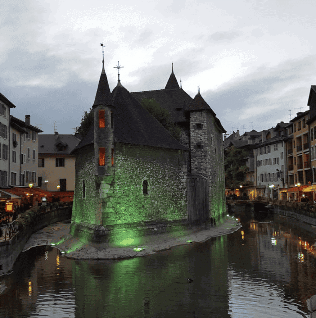 Le Palais de I'Ile, Annecy. a mideieval castle in the middle of the Thiou canal at dusk